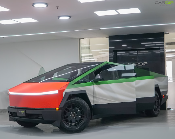 Tesla Cybertruck wrapped in UAE flag colors with a sleek matte finish, showcasing professional car wrapping and PPF services at Cardip Auto Care, LLC. Dubai.
